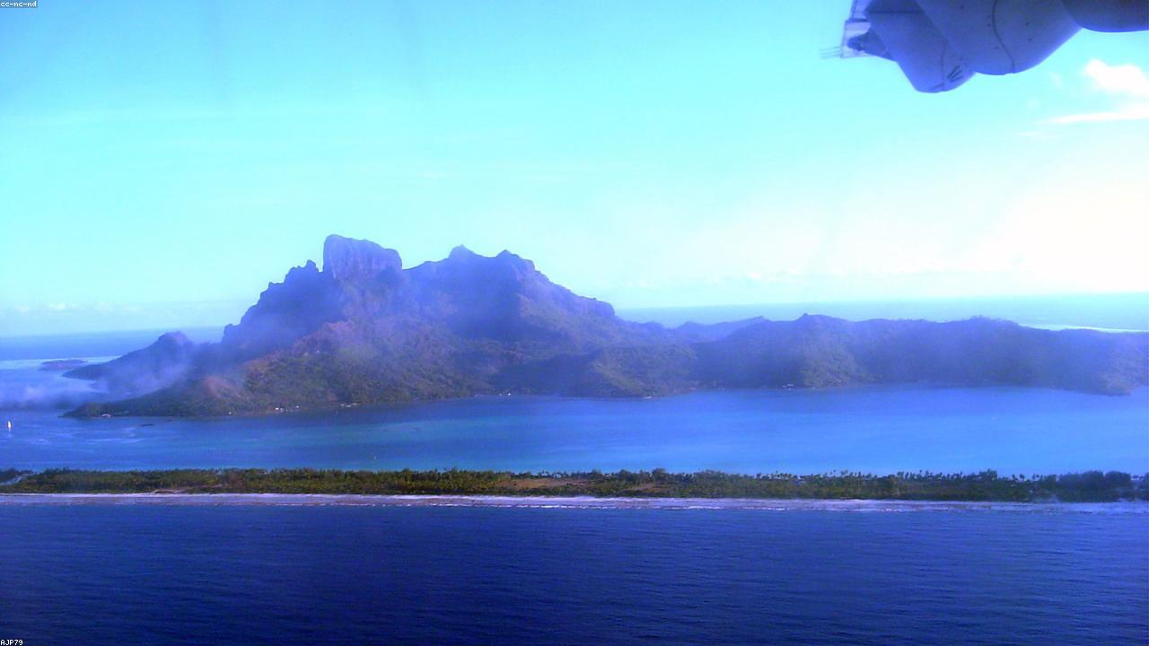 Overwater bungalows on the lagoon at Bora Bora with Mount Otemanu behind.